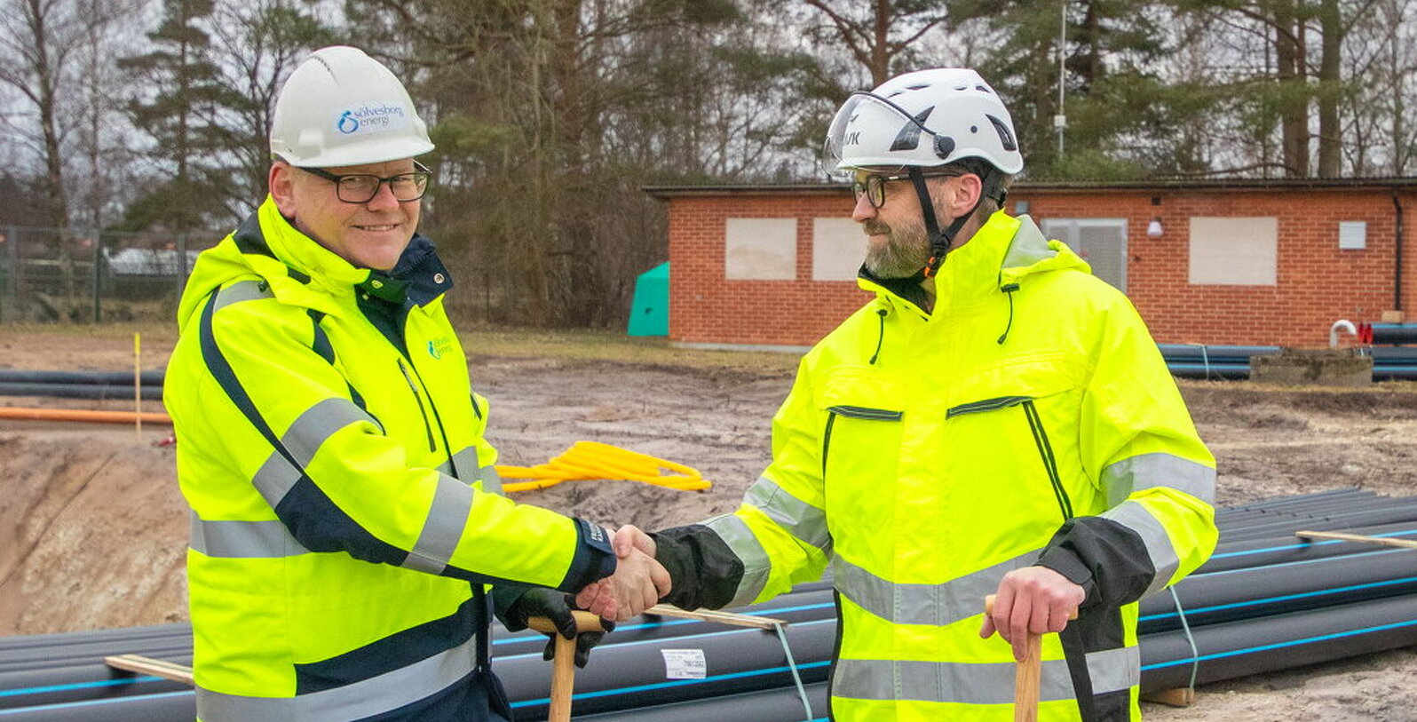 Bild på Roger Mattsson, vd Sölvesborg Enegi och Joakim Wallberg, vd Bromölla Energi och Vatten som skakar hand med varandra..